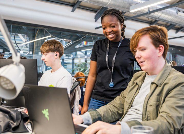 Young boys and a girl who are part of the Patch accelerator staring at computer screens in Dogpatch Labs and smiling.