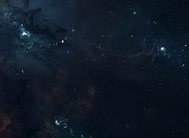 An image of distant galaxies and clusters in the universe. Faint light intersperses darkness. Symbolises the dark matter and energy that Euclid will be studying.