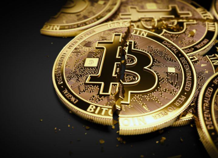 A pile of coins with the bitcoin logo, with a crack in the middle of each coin. A concept for issues in the crypto sector.
