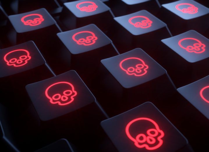 Close-up of a computer keyboard where all keys bear a glowing red skull, indicating a cyberattack.
