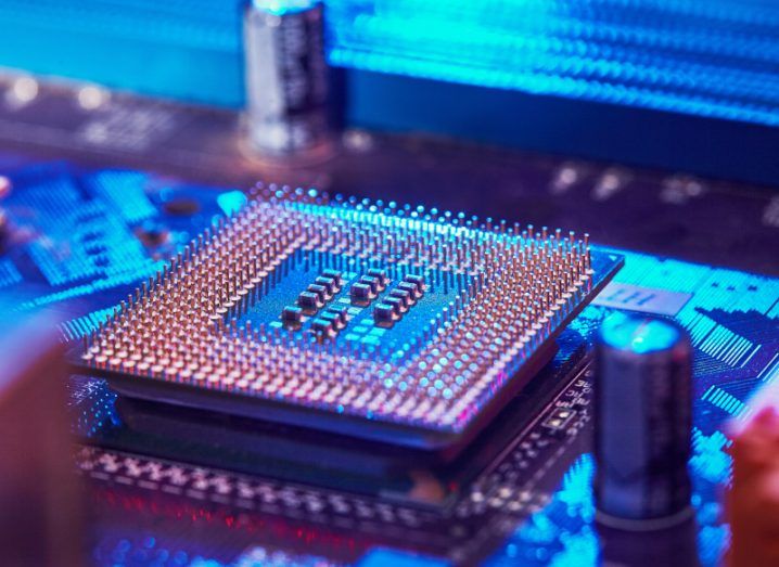 A computer chip on a motherboard, with a blue light shining on it.