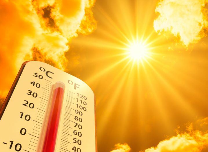 An image of the sun in the sky with a thermometer to the side of the image. Used as a concept to show rising temperatures.