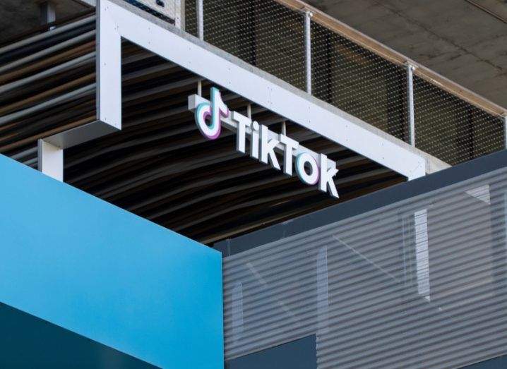 The TikTok logo on the front of a building, with a small blue wall under it.