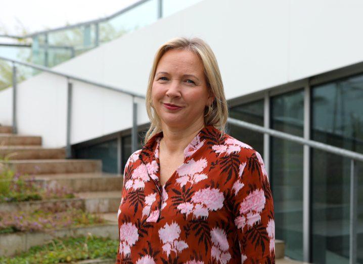 A woman with blonde hair stands outdoors at the foot of a set of steps. She is Eimear Hickey of Aurora Telecom.