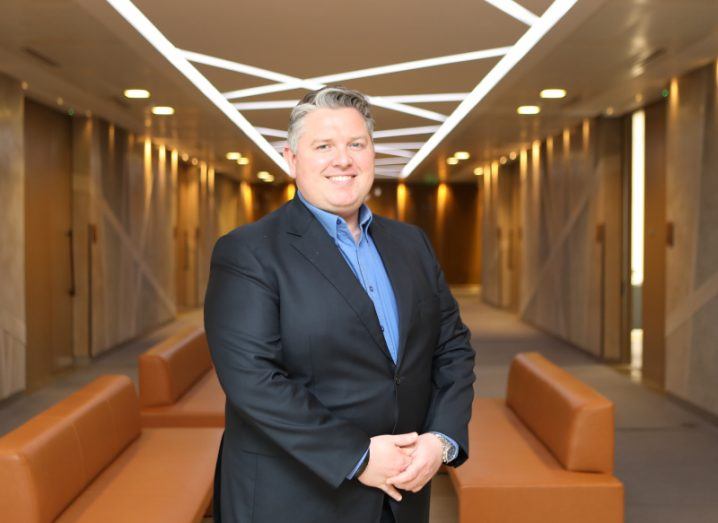 A man in a suit stands in a long office corridor. He is William Fry’s Barry Scannell.