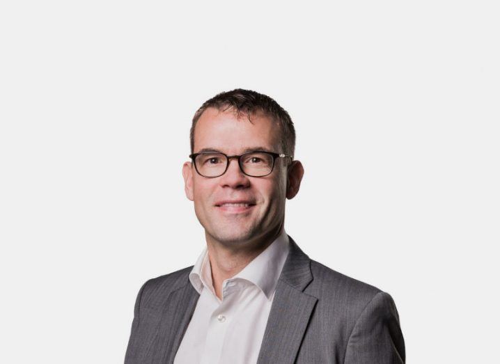 Headshot of Kim Gunnelius of Verne global, wearing a grey suit and standing in a white background.