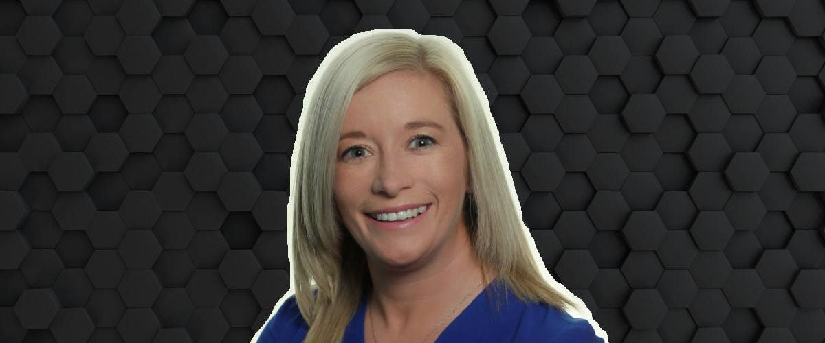 A woman with blonde hair smiles at the camera wearing a blue blouse. She is Kate Feeney, a senior manager at Fidelity Investments.