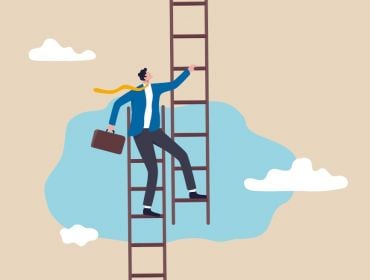 A person stands on the top of one ladder while stepping onto a different one, symbolising a career pivot.