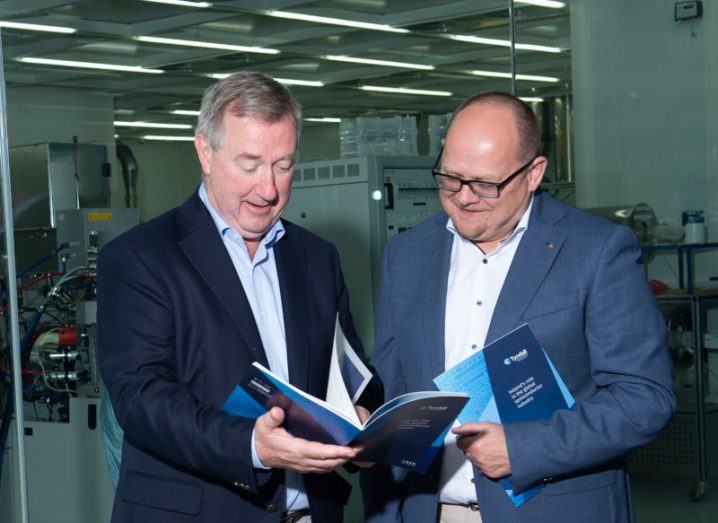 Two men in suits reading a document together. They are the chair and CEO of Tyndall.