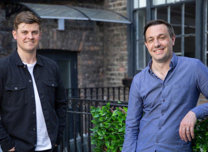 Two men standing next to each other with a building in the background. They are the founders of Wayflyer.
